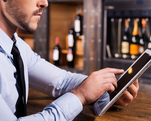 man looking at ipad inside liquor store | ;iquor store POS