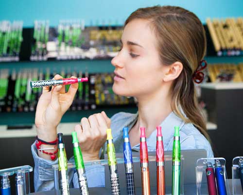 a woman testing vapes in a vape store | vape store pos