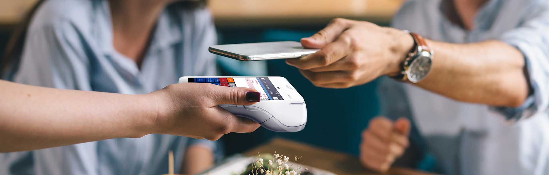 man paying for meal with phone | contactless pos