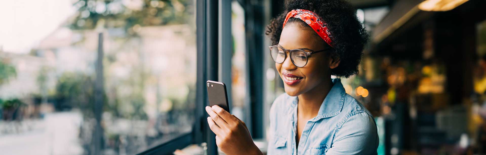 woman in a blue shirt looking at phone i a restaurant | gift and loyalty pos