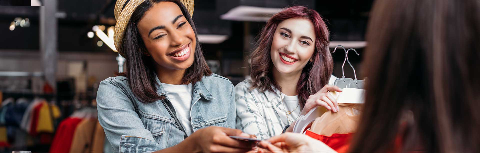 two young women paying for their purchase in a retail setting | retail pos