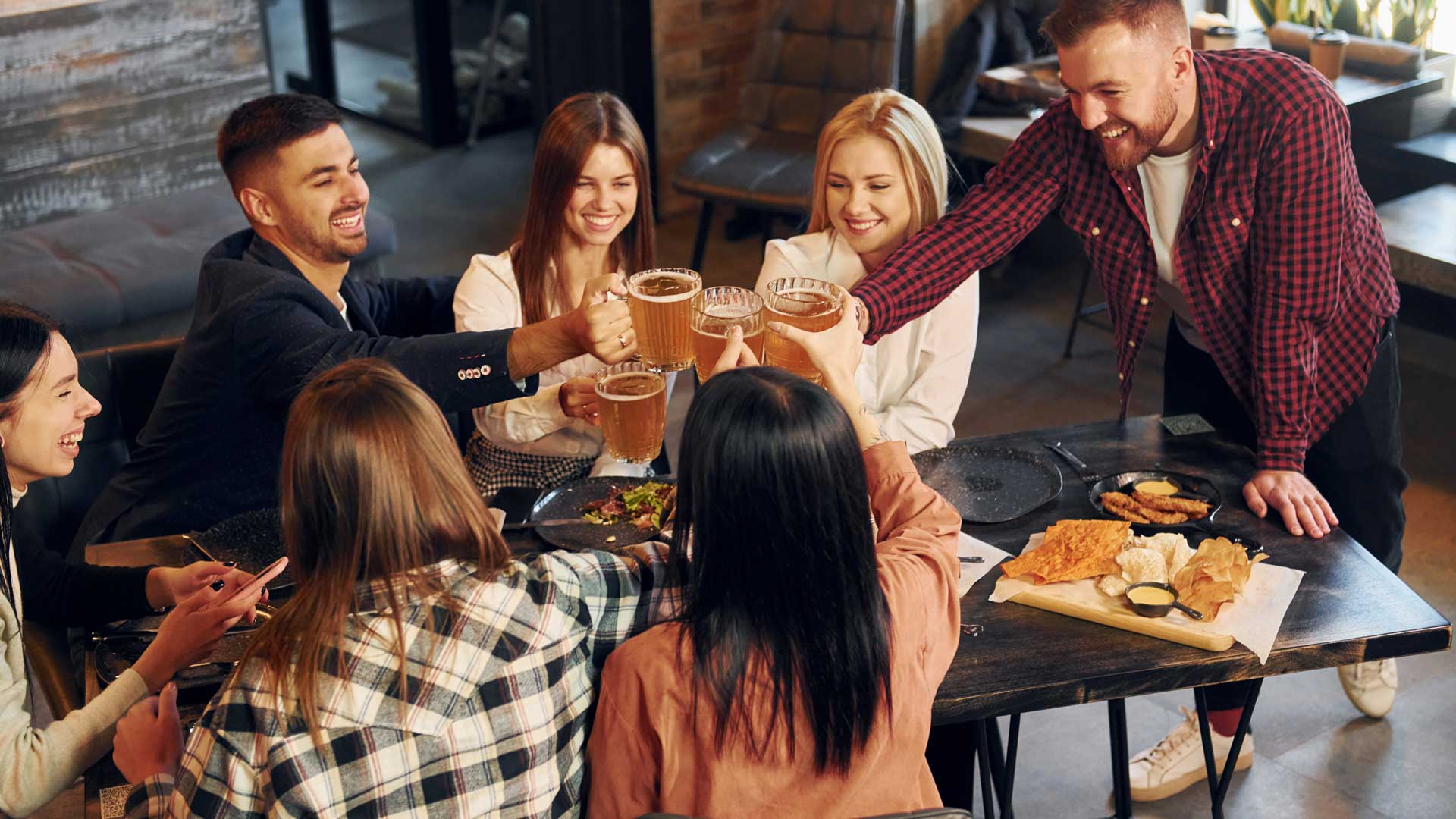 group of friend toasting at a bar table