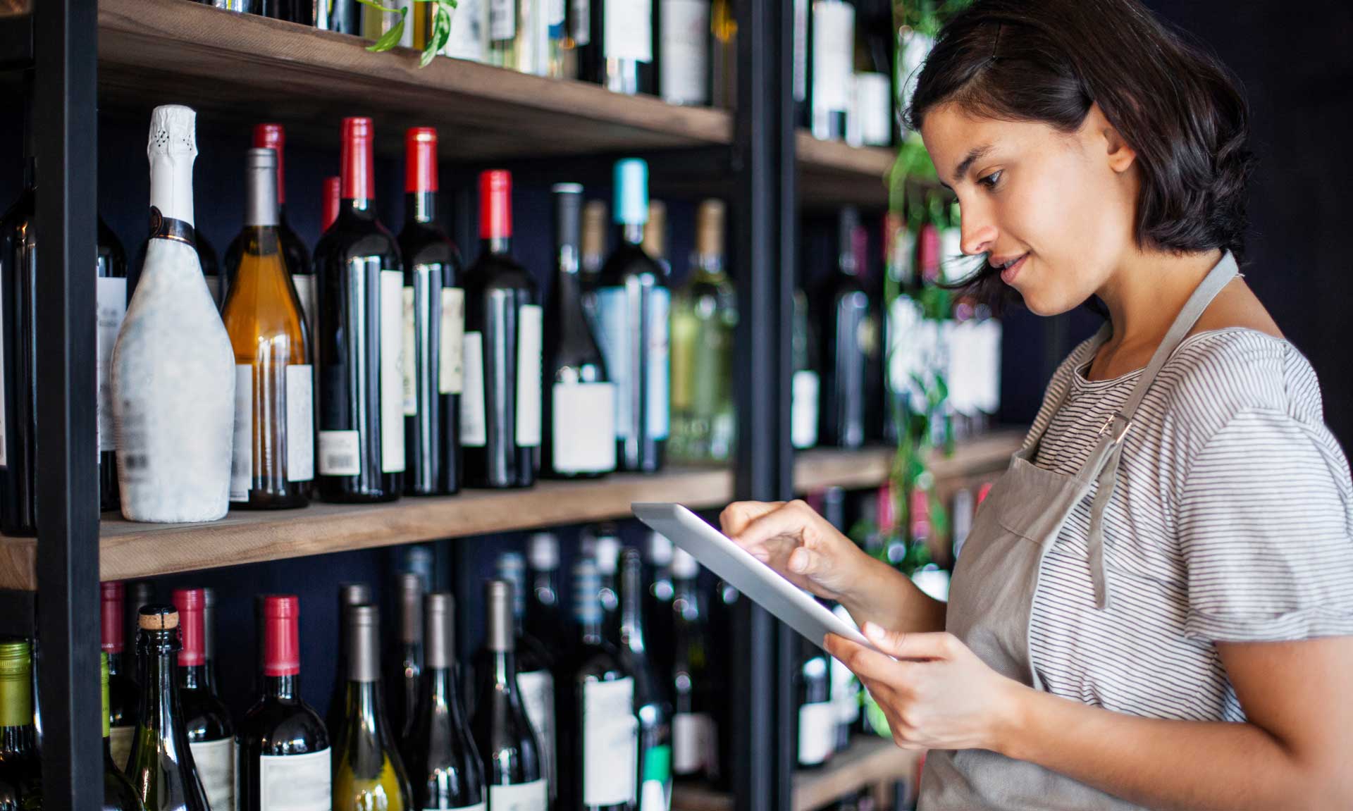 smiling woman working inside a liquor store | liquor store pos