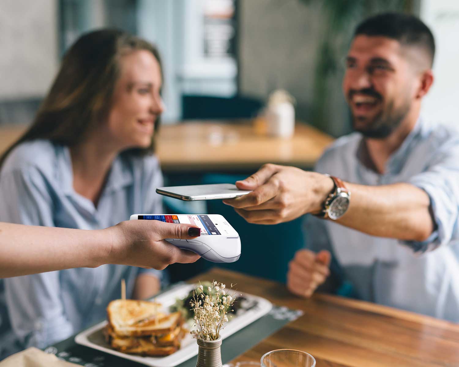 man paying for meal with phone | payment solutions