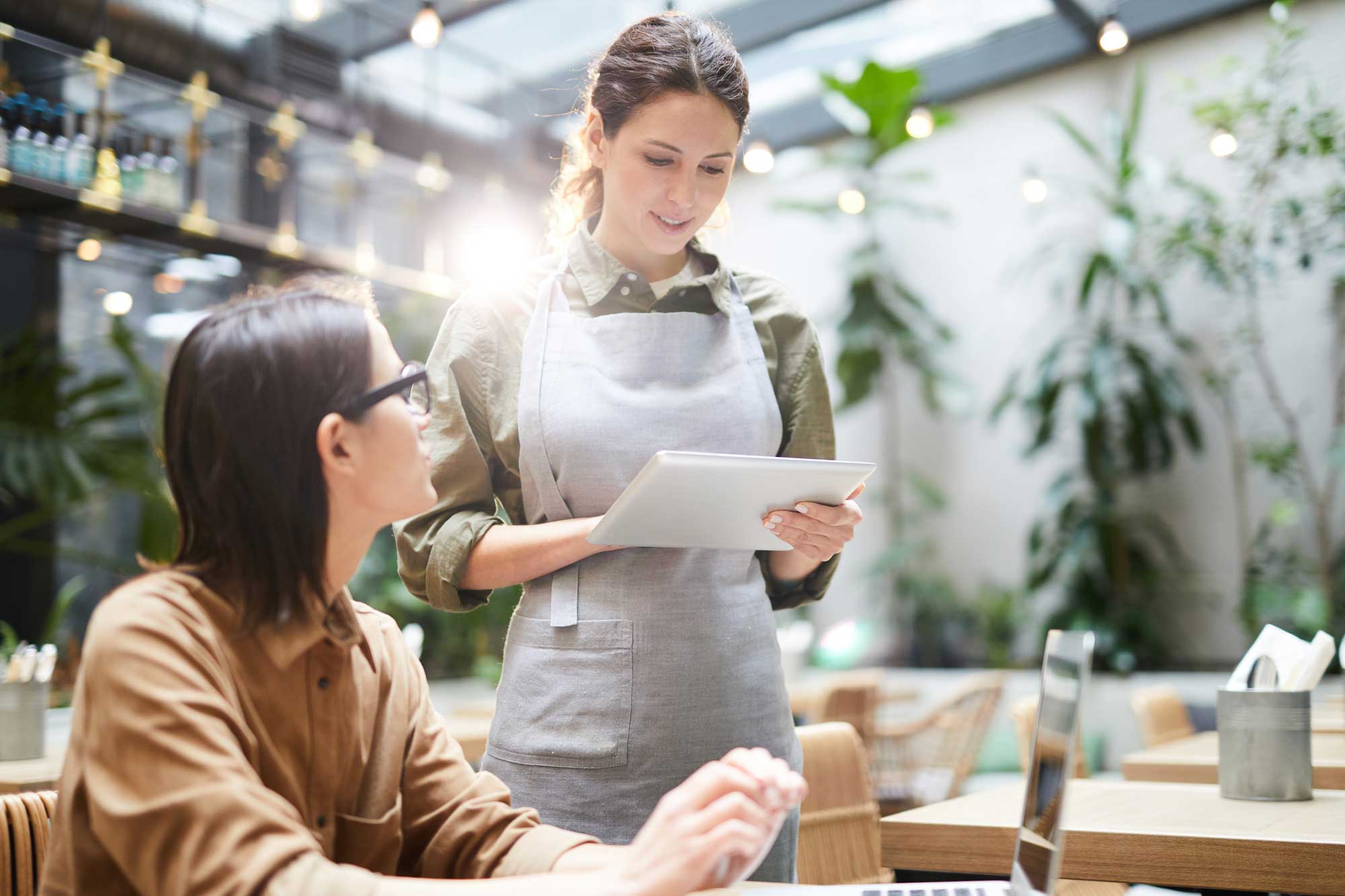 woman taking an order at the table | table service ipad POS